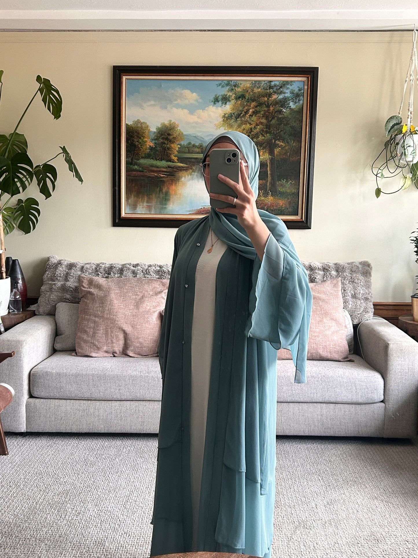 Elegant layered sage green abaya showcasing contemporary design and modest fashion.
