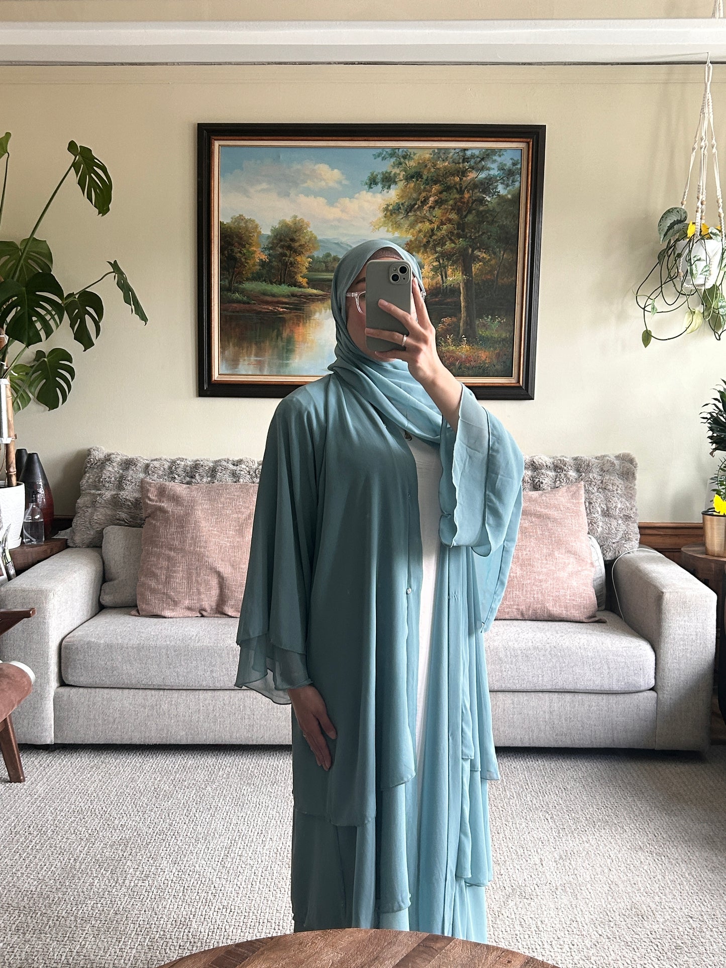 Elegant layered sage green abaya showcasing contemporary design and modest fashion.