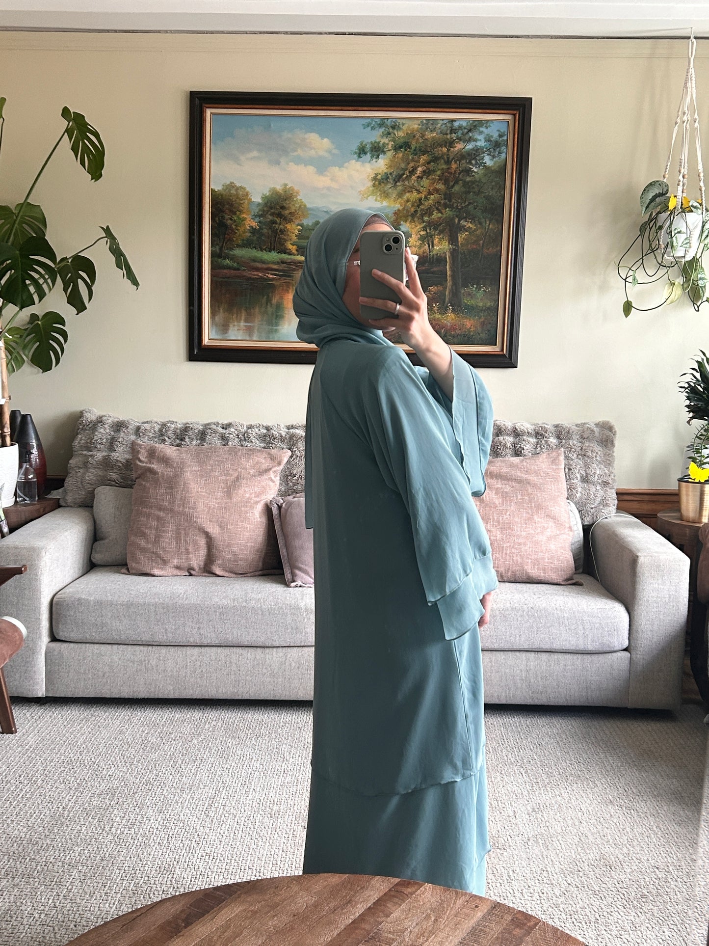 Elegant layered sage green abaya showcasing contemporary design and modest fashion.